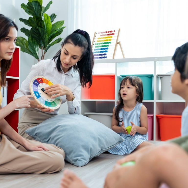 Niños y adultos en un aula colorida, interactuando con un material educativo.